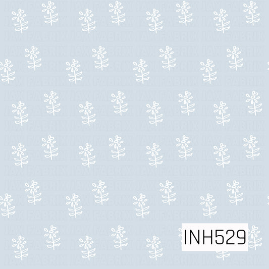 A soft, minimal floral design featuring simple hand-drawn white flowers scattered across a pale powder blue background. The delicate linework and airy spacing give this pattern a sweet, understated vintage feel.
