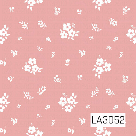 A delicate scattered floral featuring creamy white blossoms, tiny posies, and petite leafy sprigs on a soft rosy pink background. The airy layout and lightly textured, hand-painted style give it a sweet vintage cottage feel.
