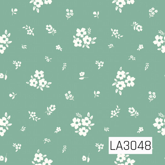 A delicate scattered floral featuring creamy white blossoms, tiny flower clusters, and petite leafy sprigs on a soft sage green background. The airy layout and slightly textured, hand-painted shapes give it a sweet vintage cottage feel.
