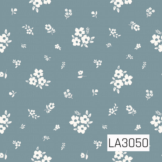A sweet scattered floral featuring creamy white blossoms, tiny posies, and delicate leafy sprigs across a soft chambray blue background. The loose, hand-painted texture and spacious arrangement give it a charming vintage cottage feel.
