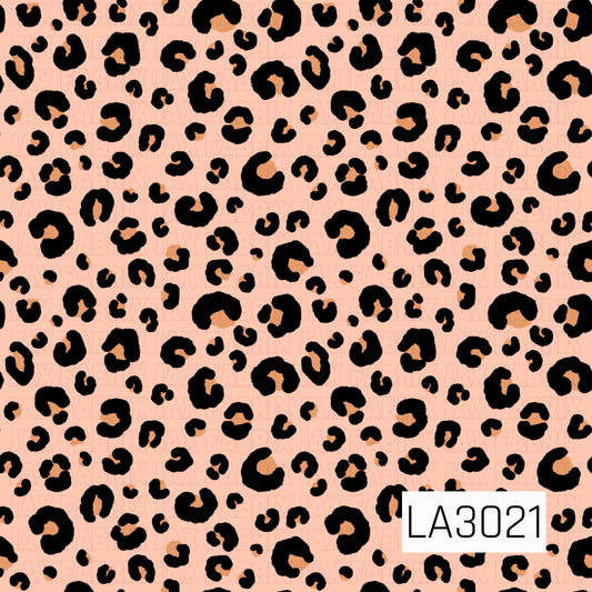 A soft peach background covered in bold black leopard spots with warm tan centers for a fun, playful look.
