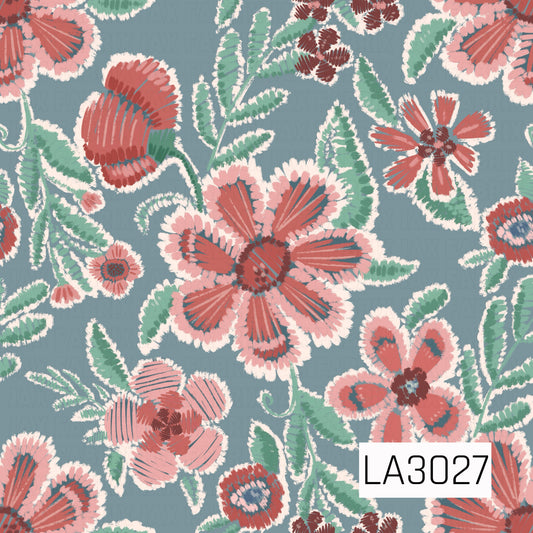 A bold embroidered-style floral print featuring coral and blush blooms with minty green foliage on a dusty blue background. Creamy stitched accents and textured brushwork give the design a charming handmade, vintage-inspired feel.
